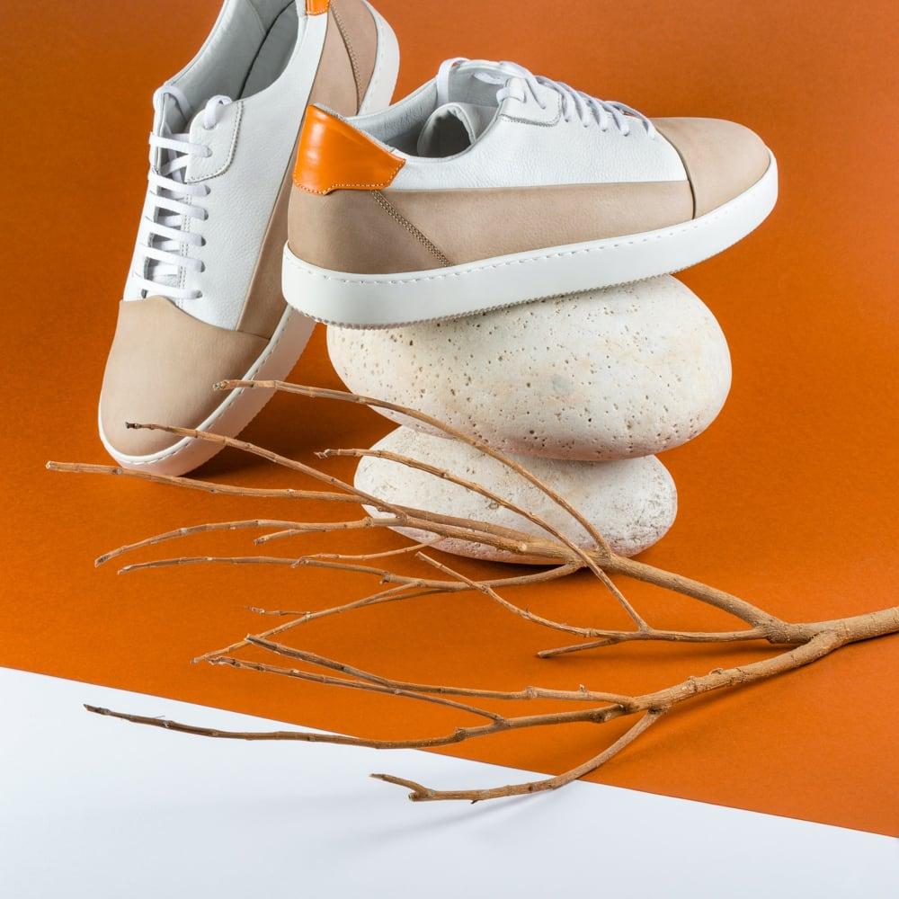 Top-down shot of the product, white sneakers on orange background