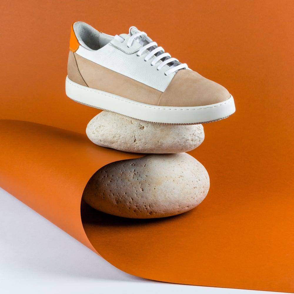 Side shot of the product, white sneakers on orange background